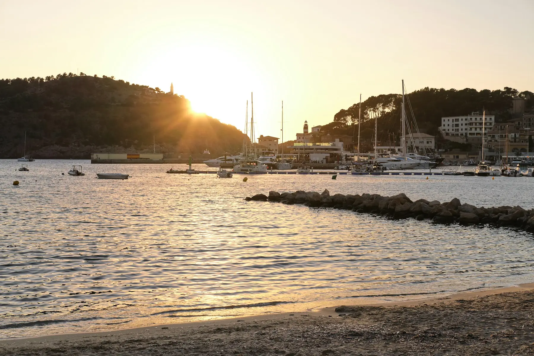 Puerto al atardecer con barcos en la bahía