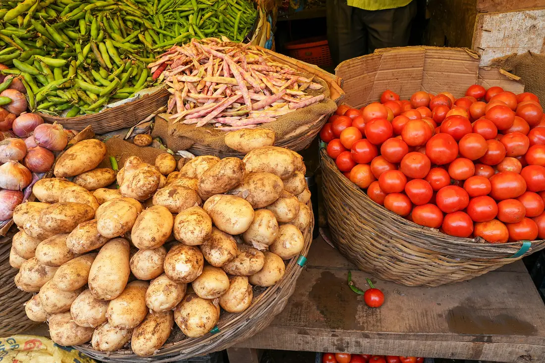 Patatas, tomates y judías en un puesto de mercado