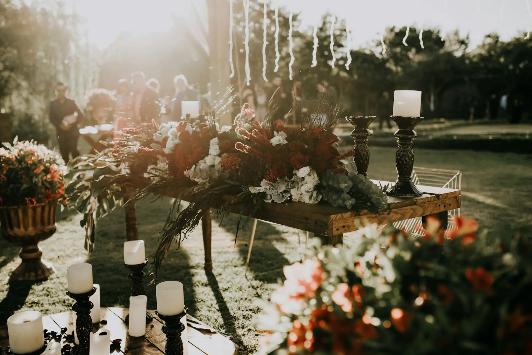 Mesa larga con velas y flores preparada para un evento