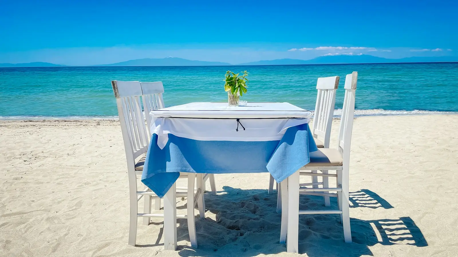 Mesa vestida de blanco junto al mar