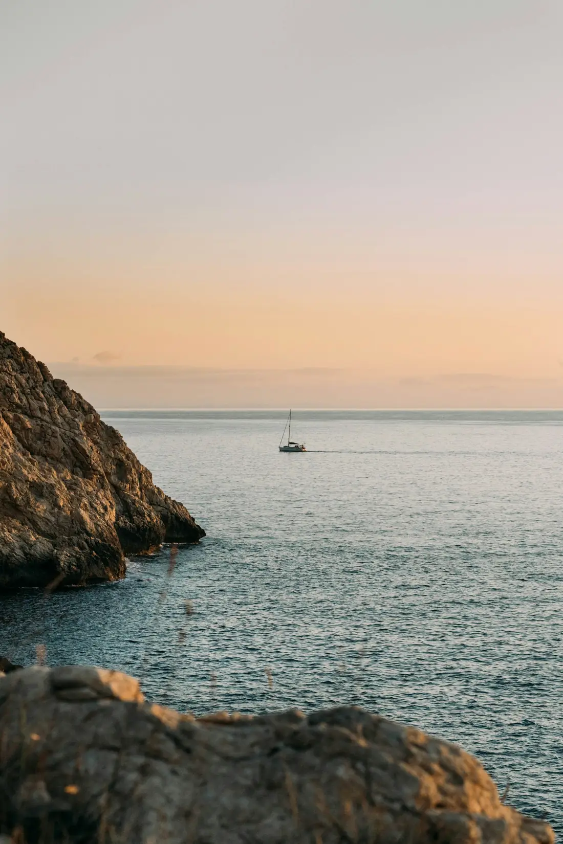 Velero frente a la costa al atardecer